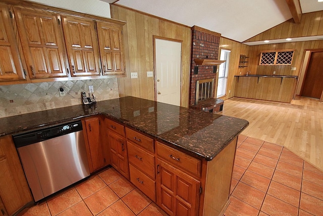 606 County Road 1947, Yantis, TX 75497 - kitchen featuring stainless steel dishwasher, a peninsula, wooden walls, a fireplace, and light tile patterned floors