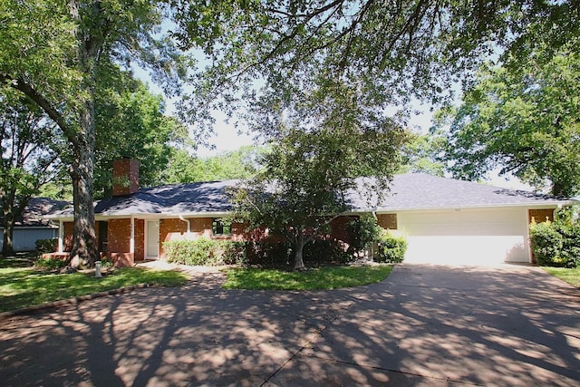 606 County Road 1947, Yantis, TX 75497 - single story home with asphalt driveway, a chimney, a garage, and brick siding