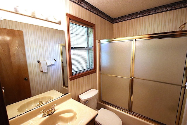 606 County Road 1947, Yantis, TX 75497 - full bathroom featuring toilet, wallpapered walls, bath / shower combo with glass door, vanity, and a textured ceiling