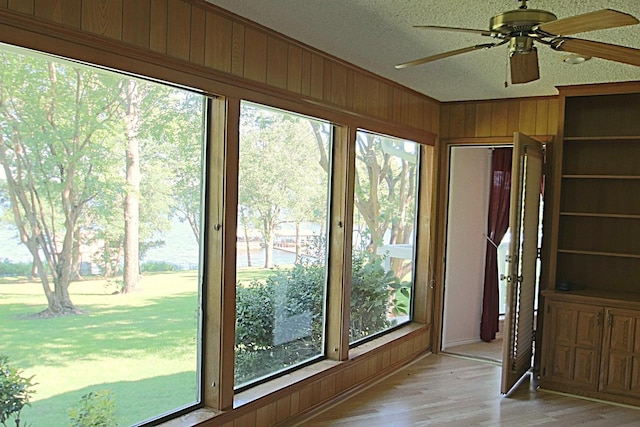 606 County Road 1947, Yantis, TX 75497 - unfurnished sunroom featuring wood finished floors, wooden walls, and a textured ceiling