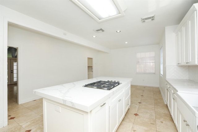 4603 Joyce Blvd, Houston, TX 77084 - kitchen with stainless steel gas stovetop, a kitchen island, light tile patterned floors, decorative backsplash, and recessed lighting