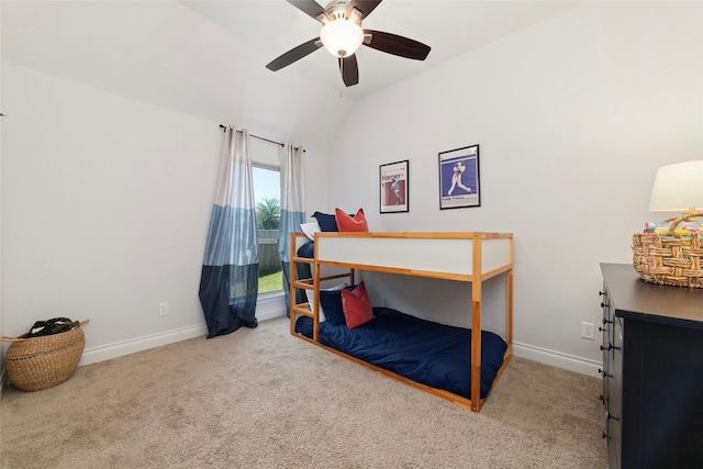 carpeted bedroom with vaulted ceiling, baseboards, and ceiling fan