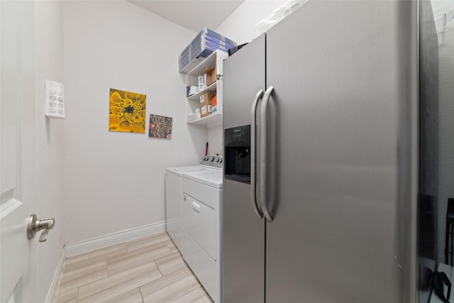 clothes washing area featuring separate washer and dryer and baseboards