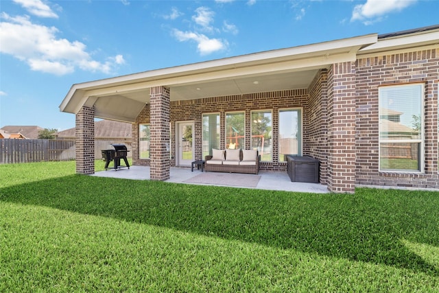back of house with brick siding, a patio, and an outdoor living space