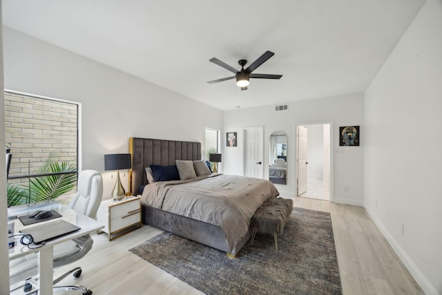 bedroom with light wood finished floors, a desk, ceiling fan, and baseboards