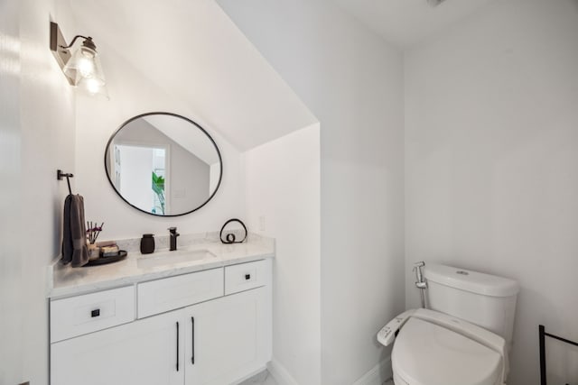 half bathroom featuring toilet, baseboards, and vanity