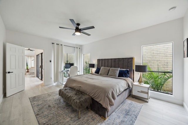 bedroom featuring light wood-style floors, a ceiling fan, and baseboards
