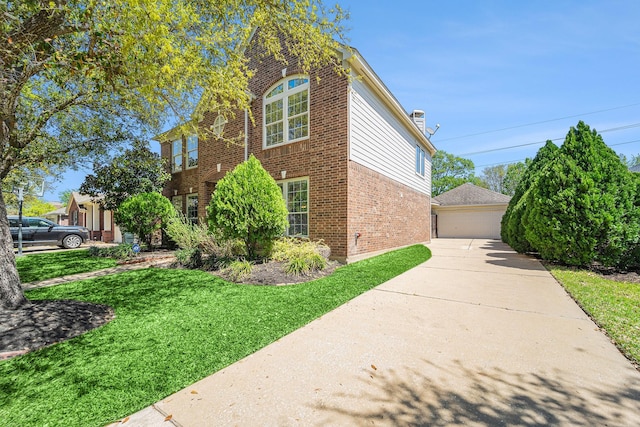 11018 Jadestone Creek Ln, Cypress, TX 77433 - view of property exterior featuring brick siding, a lawn, a detached garage, and an outbuilding