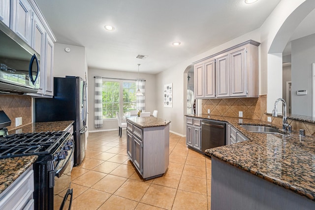 11018 Jadestone Creek Ln, Cypress, TX 77433 - kitchen with black range with gas cooktop, stainless steel microwave, dishwashing machine, a sink, and arched walkways