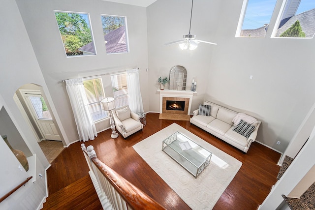 11018 Jadestone Creek Ln, Cypress, TX 77433 - living room with wood finished floors, arched walkways, a towering ceiling, a tile fireplace, and ceiling fan