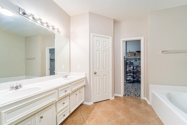11018 Jadestone Creek Ln, Cypress, TX 77433 - bathroom featuring a garden tub, double vanity, a walk in closet, tile patterned flooring, and baseboards