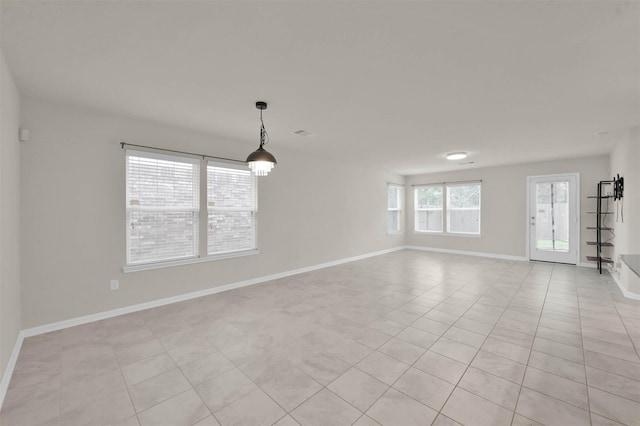 unfurnished room featuring baseboards and light tile patterned flooring