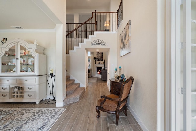 202 Bentwater Ln, Clute, TX 77531 - entryway with stairs, a warm lit fireplace, ornamental molding, baseboards, and wood finished floors