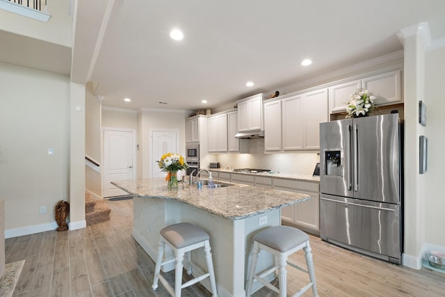 202 Bentwater Ln, Clute, TX 77531 - kitchen with stainless steel appliances, crown molding, a kitchen island with sink, light wood-style flooring, and recessed lighting