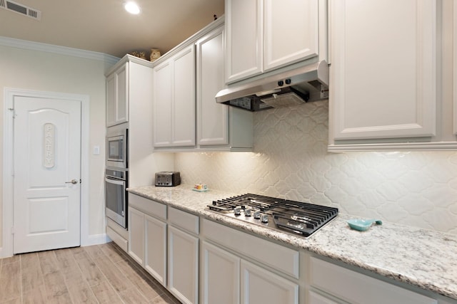 202 Bentwater Ln, Clute, TX 77531 - kitchen featuring under cabinet range hood, stainless steel appliances, ornamental molding, backsplash, and light wood-style flooring