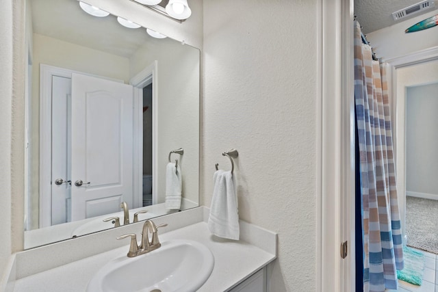202 Bentwater Ln, Clute, TX 77531 - full bathroom with vanity, a textured wall, a textured ceiling, and curtained shower