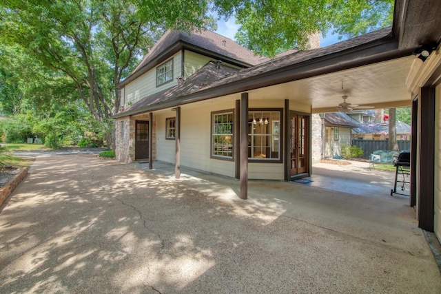view of property exterior featuring a patio area, fence, a ceiling fan, and a chimney