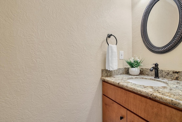 bathroom with vanity and a textured wall