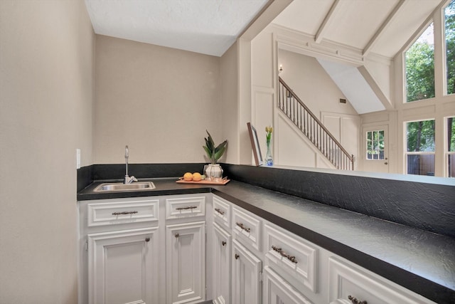 bar featuring a sink, healthy amount of natural light, and stairway