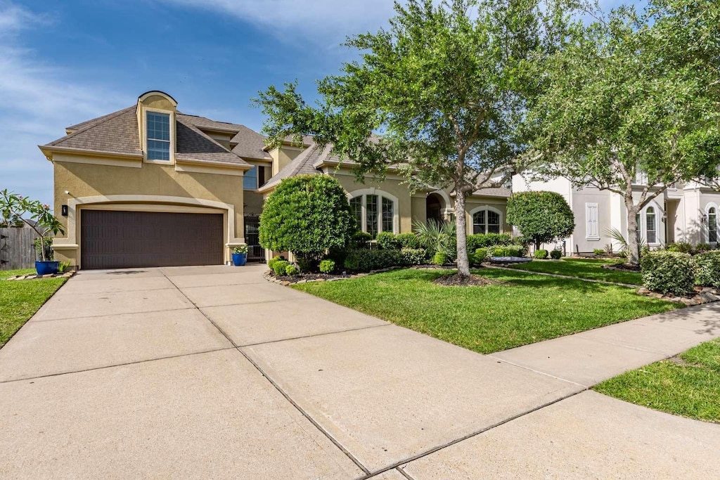 4528 Estella Ct, League City, TX 77573 - view of front of house with stucco siding, a front lawn, a garage, and concrete driveway