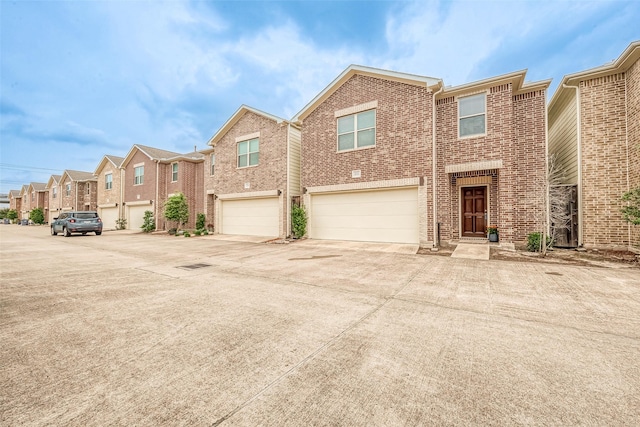 3722 Main Poplar Dr, Houston, TX 77025 - view of front of house with brick siding, a garage, concrete driveway, and a residential view