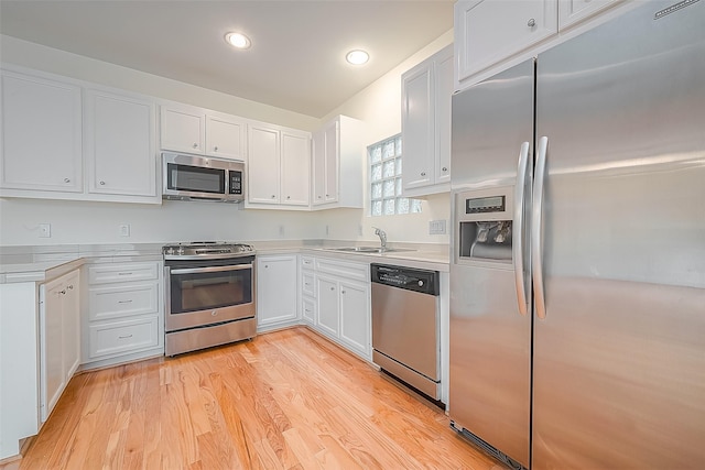 3722 Main Poplar Dr, Houston, TX 77025 - kitchen featuring appliances with stainless steel finishes, light countertops, white cabinetry, a sink, and recessed lighting