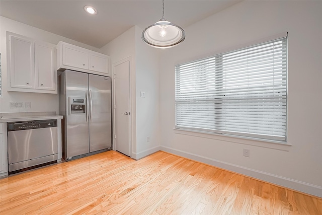 3722 Main Poplar Dr, Houston, TX 77025 - kitchen with appliances with stainless steel finishes, white cabinets, baseboards, light wood finished floors, and light countertops