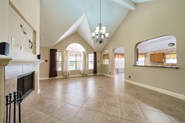 7810 Broken Arrow St, Baytown, TX 77521 - unfurnished living room featuring tile patterned flooring, arched walkways, a tiled fireplace, high vaulted ceiling, and a chandelier