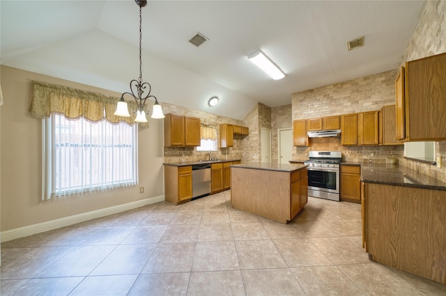 7810 Broken Arrow St, Baytown, TX 77521 - kitchen featuring stainless steel appliances, vaulted ceiling, decorative backsplash, a center island, and brown cabinets
