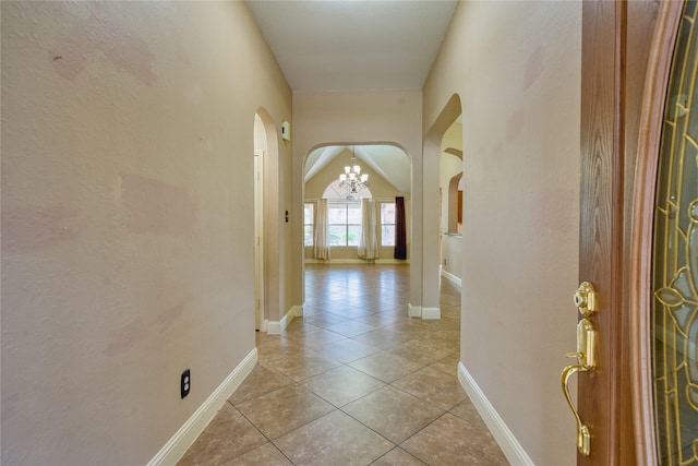 7810 Broken Arrow St, Baytown, TX 77521 - corridor featuring arched walkways, a chandelier, light tile patterned flooring, and baseboards