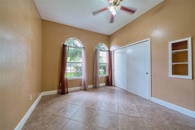 7810 Broken Arrow St, Baytown, TX 77521 - tiled spare room with a textured wall, a ceiling fan, and baseboards