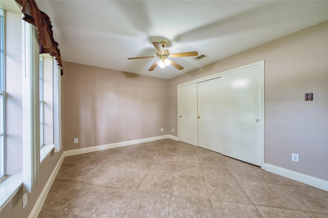 7810 Broken Arrow St, Baytown, TX 77521 - unfurnished bedroom featuring a closet, ceiling fan, light tile patterned floors, and baseboards