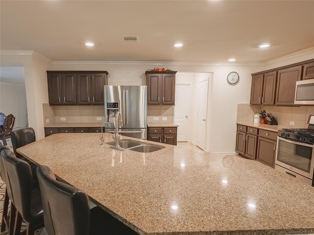 2786 Cayden Creek Way, Conroe, TX 77304 - kitchen featuring appliances with stainless steel finishes, light stone countertops, a breakfast bar, tasteful backsplash, and ornamental molding