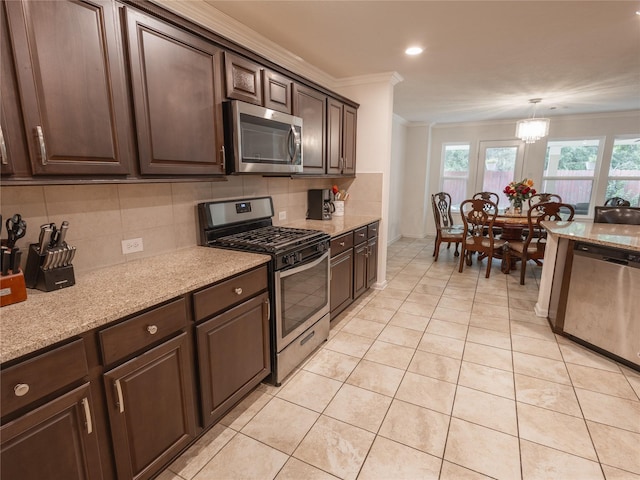 2786 Cayden Creek Way, Conroe, TX 77304 - kitchen featuring appliances with stainless steel finishes, crown molding, decorative backsplash, dark brown cabinetry, and light stone counters