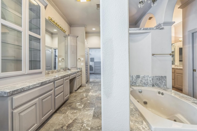 21 Aston Gln, San Antonio, TX 78257 - bathroom featuring crown molding, vanity, a tub with jets, and stone finish flooring