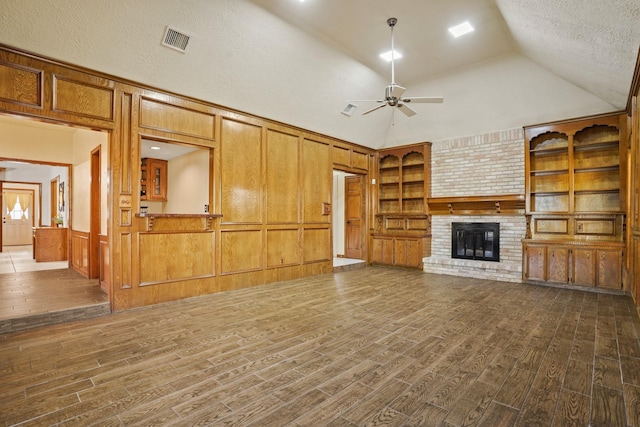13102 Lake Mist Dr, Cypress, TX 77429 - unfurnished living room with ceiling fan, dark wood-style floors, a fireplace, vaulted ceiling, and built in shelves