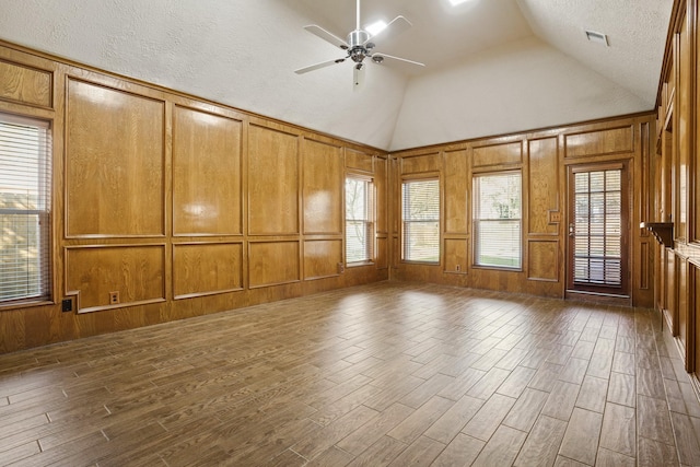 13102 Lake Mist Dr, Cypress, TX 77429 - spare room featuring lofted ceiling, dark wood-type flooring, a ceiling fan, a decorative wall, and a textured ceiling