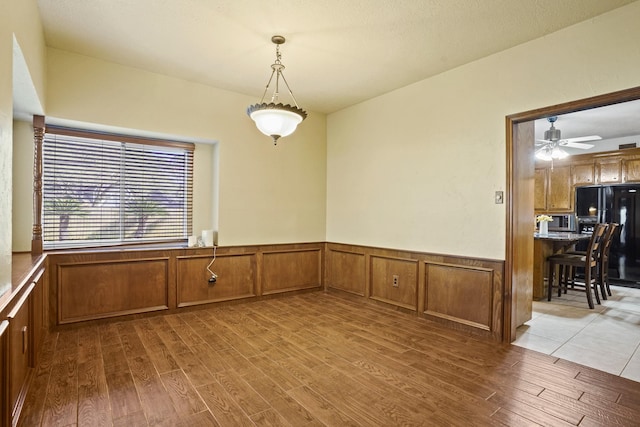 13102 Lake Mist Dr, Cypress, TX 77429 - unfurnished dining area with wood finished floors, wainscoting, and a ceiling fan