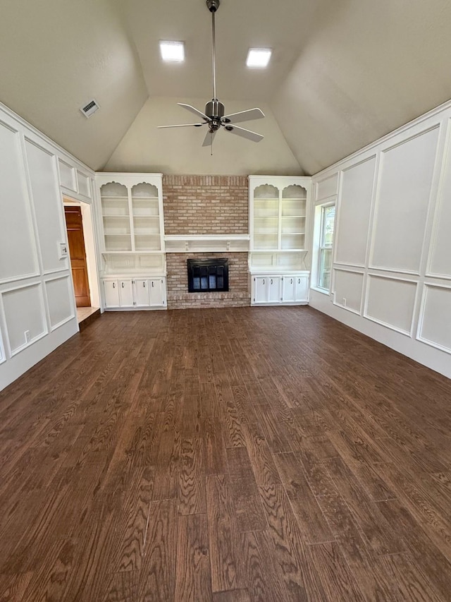 13102 Lake Mist Dr, Cypress, TX 77429 - unfurnished living room featuring a decorative wall, a ceiling fan, lofted ceiling, dark wood-type flooring, and a brick fireplace