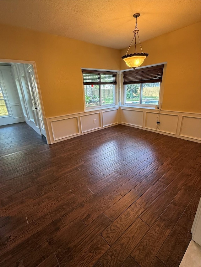 13102 Lake Mist Dr, Cypress, TX 77429 - spare room with dark wood-style floors, healthy amount of natural light, a decorative wall, a wainscoted wall, and a textured ceiling