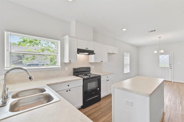3907 Lynnfield St, Houston, TX 77016 - kitchen with black range with electric cooktop, a sink, under cabinet range hood, and light wood-style floors