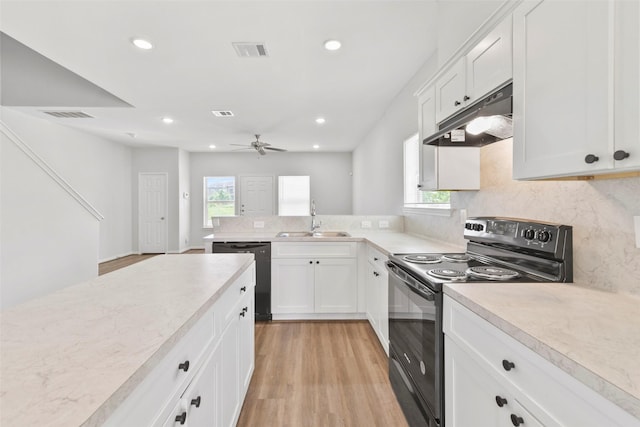 3907 Lynnfield St, Houston, TX 77016 - kitchen with black appliances, under cabinet range hood, a sink, light countertops, and light wood-style floors