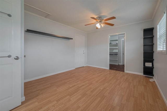1402 W Norris, El Campo, TX 77437 - unfurnished bedroom with light wood-type flooring, ornamental molding, baseboards, attic access, and a ceiling fan