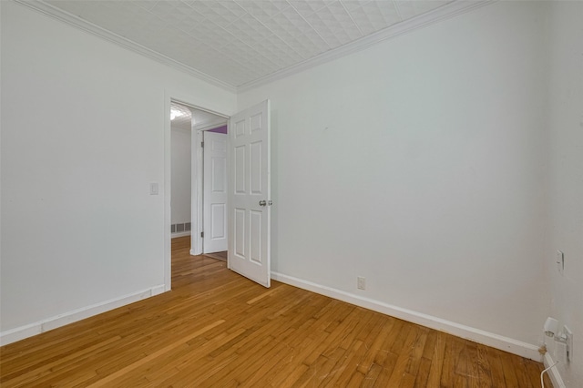 1402 W Norris, El Campo, TX 77437 - empty room featuring crown molding, light wood-type flooring, and baseboards