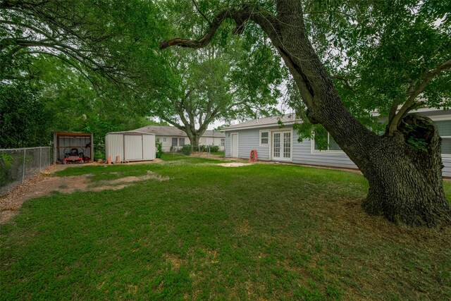 1402 W Norris, El Campo, TX 77437 - view of yard with french doors, a shed, an outdoor structure, and a detached carport