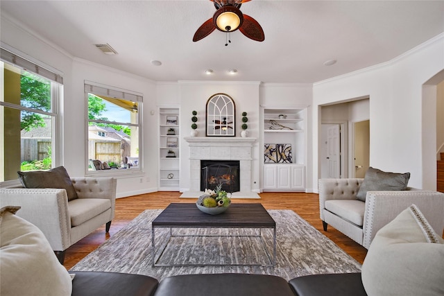 19715 Satinwood Trl, Humble, TX 77346 - living room with ceiling fan, ornamental molding, a fireplace, built in shelves, and wood finished floors