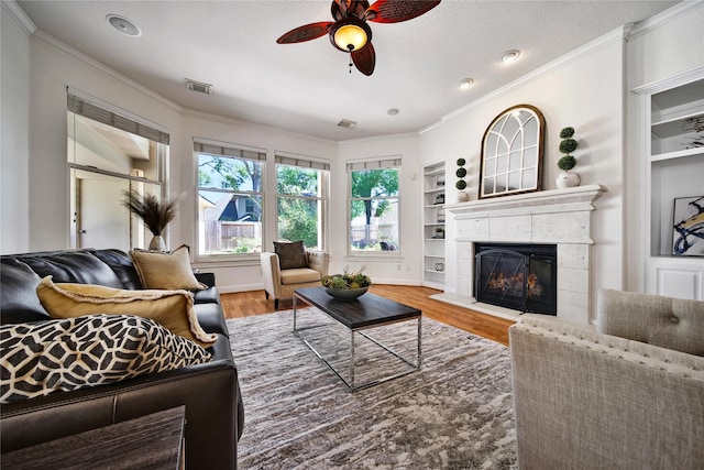 19715 Satinwood Trl, Humble, TX 77346 - living room featuring ceiling fan, crown molding, wood finished floors, a fireplace, and built in features
