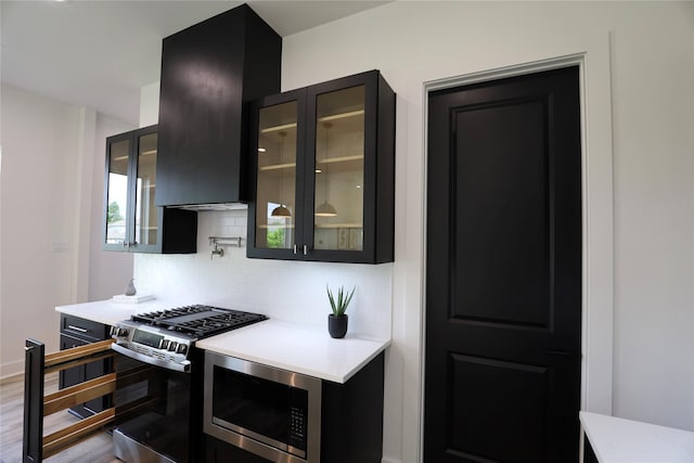 609 E 38th St, Houston, TX 77022 - kitchen with appliances with stainless steel finishes, tasteful backsplash, light countertops, and dark cabinets