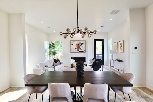 609 E 38th St, Houston, TX 77022 - dining area featuring baseboards, light wood finished floors, a chandelier, recessed lighting, and a fireplace