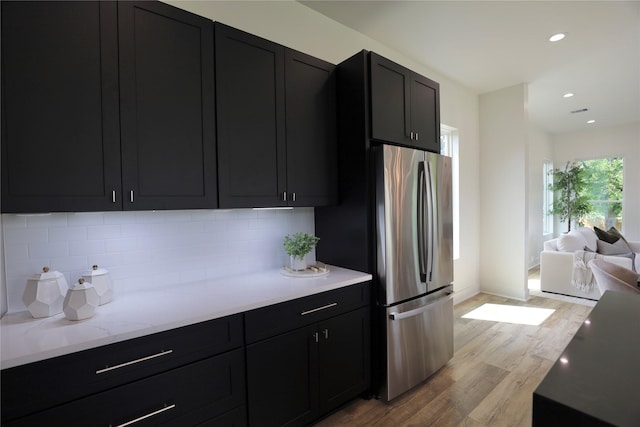 609 E 38th St, Houston, TX 77022 - kitchen featuring freestanding refrigerator, dark cabinets, light wood finished floors, and recessed lighting